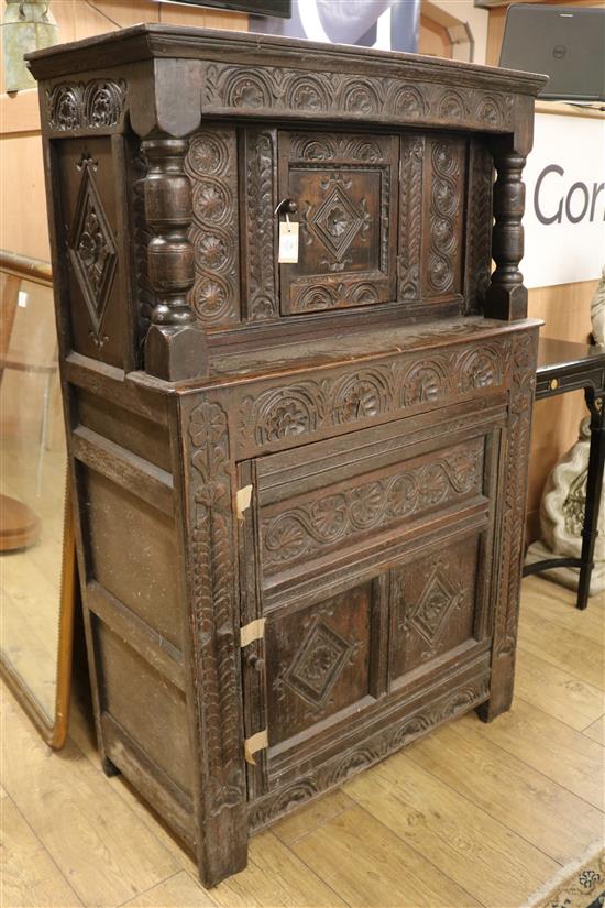 A 17th century style carved oak court cupboard having lunette-carved frieze, flower-heads and lozenges W.97cm